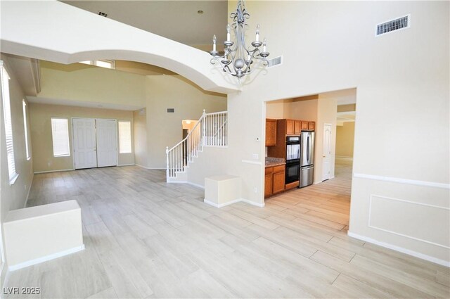 5808 Amber Station Ave, Las Vegas, NV 89131 - foyer featuring a towering ceiling, arched walkways, stairs, a chandelier, and baseboards