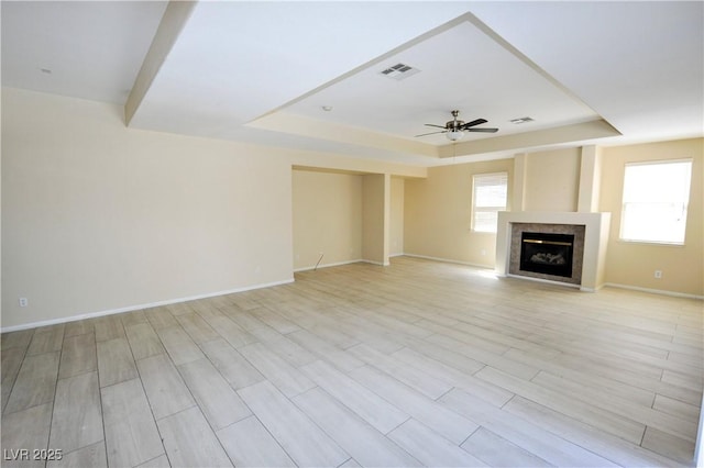 5808 Amber Station Ave, Las Vegas, NV 89131 - unfurnished living room with a raised ceiling, ceiling fan, a fireplace, and baseboards