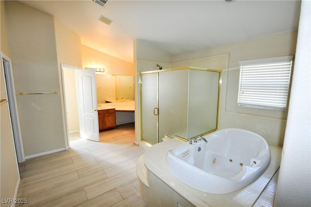 5808 Amber Station Ave, Las Vegas, NV 89131 - full bath featuring a shower stall, a jetted tub, vanity, wood finished floors, and vaulted ceiling