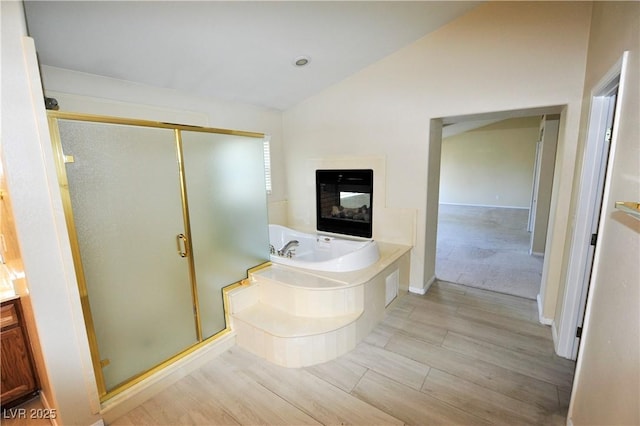 5808 Amber Station Ave, Las Vegas, NV 89131 - full bath with vaulted ceiling, a stall shower, a bath, wood finished floors, and a multi sided fireplace
