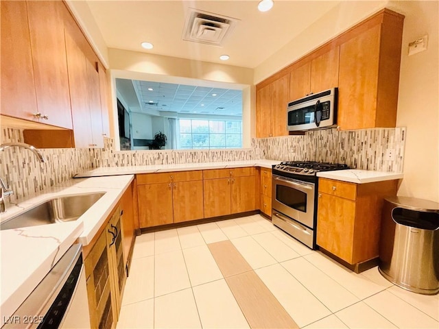 62 E Serene Ave Unit 115, Las Vegas, NV 89123 - kitchen featuring appliances with stainless steel finishes, a sink, brown cabinets, decorative backsplash, and recessed lighting