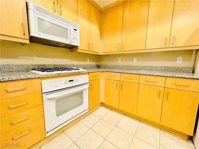 62 E Serene Ave Unit 115, Las Vegas, NV 89123 - kitchen with white appliances, light stone countertops, and light tile patterned flooring