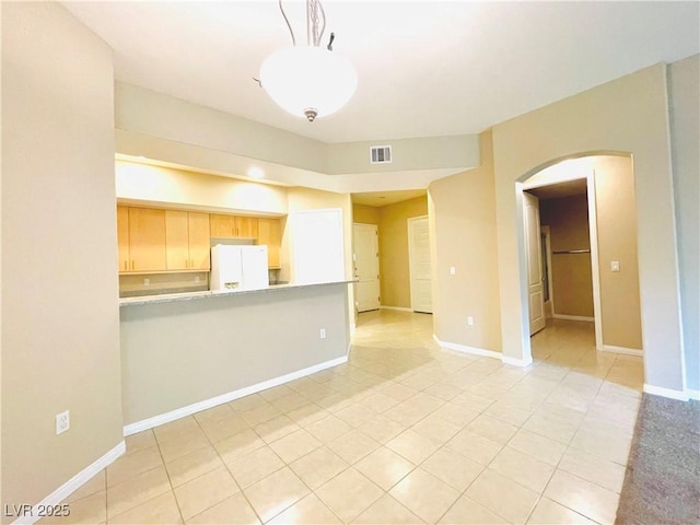 62 E Serene Ave Unit 115, Las Vegas, NV 89123 - unfurnished living room featuring arched walkways, light tile patterned floors, and baseboards