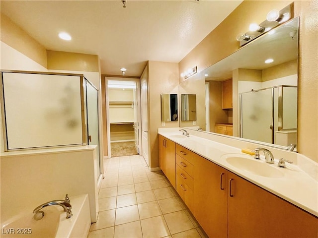 62 E Serene Ave Unit 115, Las Vegas, NV 89123 - bathroom with a shower stall, double vanity, tile patterned floors, a bath, and a walk in closet