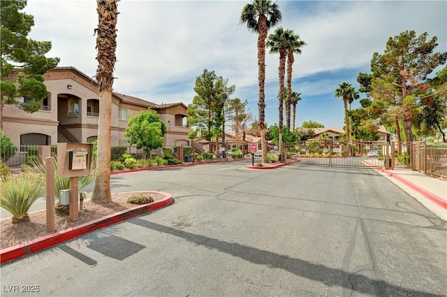 5751 E Hacienda Ave Unit 154, Las Vegas, NV 89122 - view of asphalt street featuring a gate, curbs, sidewalks, a gated entry, and a residential view