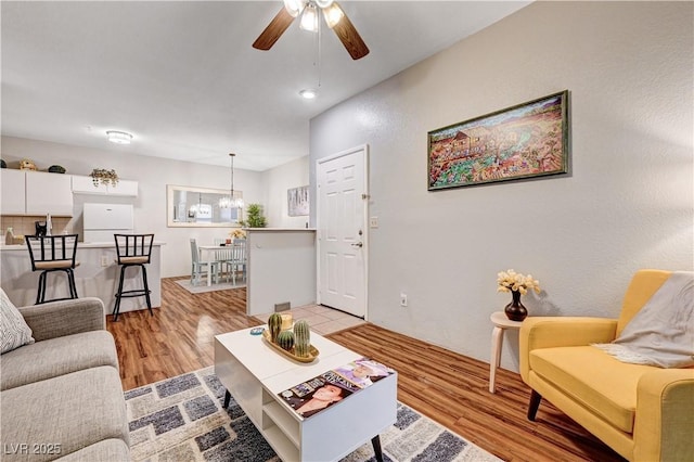 5751 E Hacienda Ave Unit 154, Las Vegas, NV 89122 - living room featuring a ceiling fan, light wood-type flooring, and a chandelier