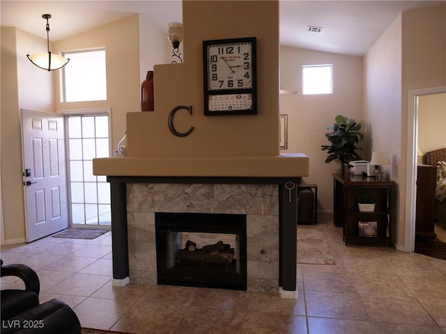 9705 Templemore Ave Unit 102, Las Vegas, NV 89129 - living area featuring vaulted ceiling, baseboards, a tile fireplace, and light tile patterned floors