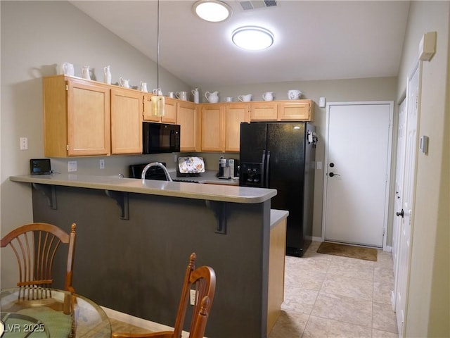 9705 Templemore Ave Unit 102, Las Vegas, NV 89129 - kitchen featuring black appliances, a peninsula, a breakfast bar area, light countertops, and vaulted ceiling