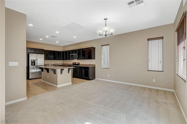 7963 Cape Brett St, Las Vegas, NV 89131 - kitchen with appliances with stainless steel finishes, light carpet, a breakfast bar area, a chandelier, and open floor plan