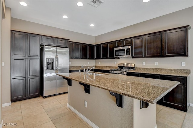 7963 Cape Brett St, Las Vegas, NV 89131 - kitchen featuring appliances with stainless steel finishes, a sink, light stone countertops, a breakfast bar area, and a center island with sink