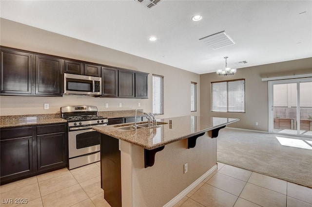 7963 Cape Brett St, Las Vegas, NV 89131 - kitchen with stainless steel appliances, a sink, baseboards, light stone counters, and a chandelier