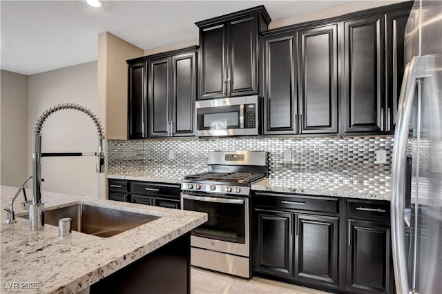 4 Lomita Heights Dr, Las Vegas, NV 89138 - kitchen with appliances with stainless steel finishes, dark cabinetry, a sink, decorative backsplash, and recessed lighting