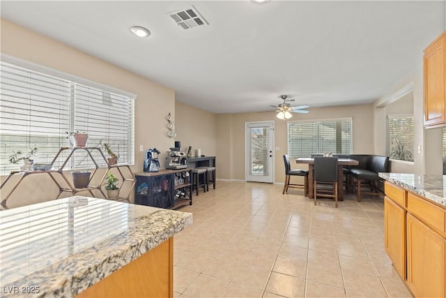 1906 Desert Sage Ave, North Las Vegas, NV 89031 - kitchen featuring a ceiling fan, light tile patterned floors, and light stone countertops