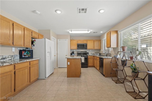 1906 Desert Sage Ave, North Las Vegas, NV 89031 - kitchen with stainless steel appliances, light tile patterned flooring, a kitchen island, recessed lighting, and light stone counters