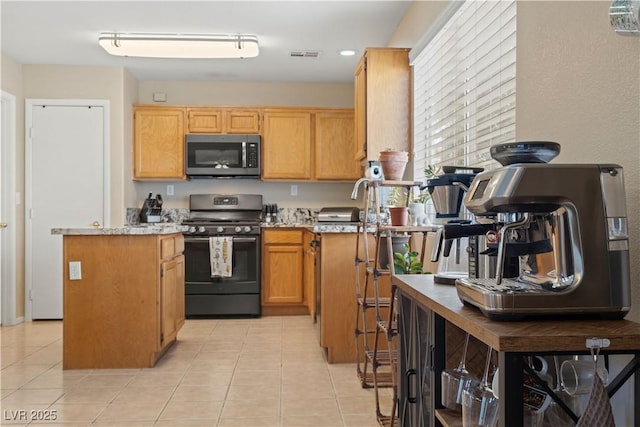 1906 Desert Sage Ave, North Las Vegas, NV 89031 - kitchen featuring stainless steel microwave, range, light tile patterned floors, and a kitchen island