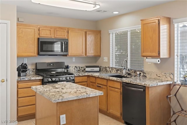 1906 Desert Sage Ave, North Las Vegas, NV 89031 - kitchen with dishwasher, black range with gas cooktop, a center island, light tile patterned floors, and light stone counters