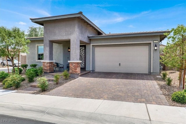 676 Otter Brook St, Henderson, NV 89011 - view of front facade featuring stucco siding, decorative driveway, an attached garage, and a porch