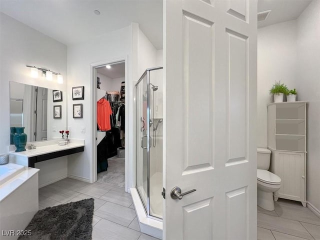 676 Otter Brook St, Henderson, NV 89011 - full bathroom featuring a shower stall, toilet, a spacious closet, baseboards, and a garden tub