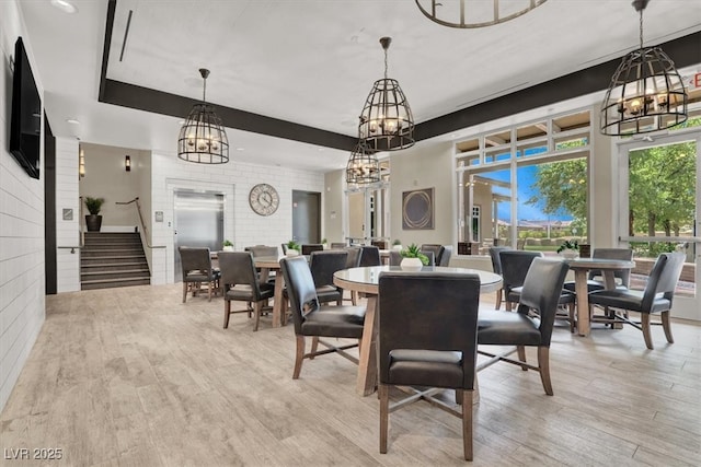 676 Otter Brook St, Henderson, NV 89011 - dining area with a chandelier, light wood-type flooring, and stairway