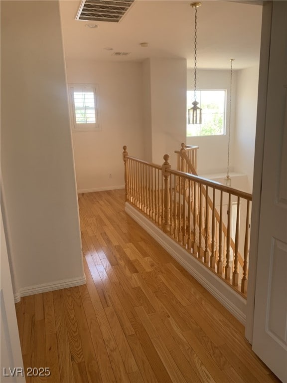 10357 Bent Willow Ave, Las Vegas, NV 89129 - corridor with an upstairs landing, baseboards, healthy amount of natural light, and light wood-style flooring