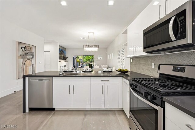 10532 Redwood Ash Ave, Las Vegas, NV 89144 - kitchen featuring stainless steel appliances, dark countertops, a peninsula, and tasteful backsplash