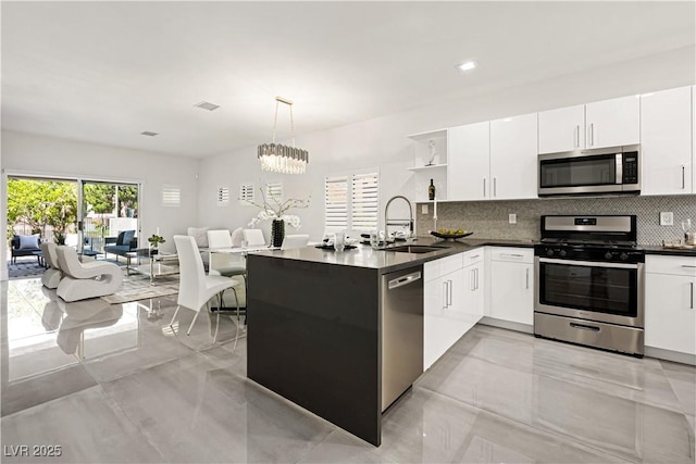 10532 Redwood Ash Ave, Las Vegas, NV 89144 - kitchen with stainless steel appliances, open shelves, backsplash, dark countertops, and white cabinets