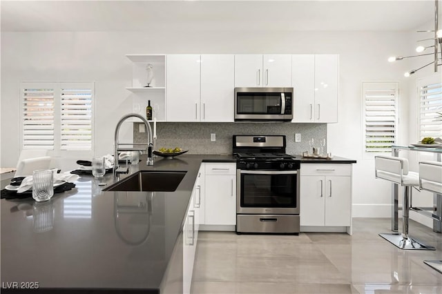 10532 Redwood Ash Ave, Las Vegas, NV 89144 - kitchen with appliances with stainless steel finishes, dark countertops, open shelves, and tasteful backsplash