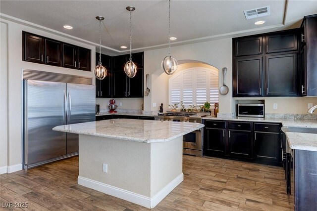 6403 Brandon Hills Ct, Las Vegas, NV 89139 - kitchen featuring stainless steel appliances, arched walkways, light wood-style flooring, light stone counters, and recessed lighting