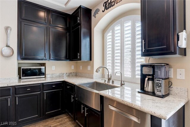 6403 Brandon Hills Ct, Las Vegas, NV 89139 - kitchen with stainless steel appliances, a sink, light stone counters, and wood finished floors