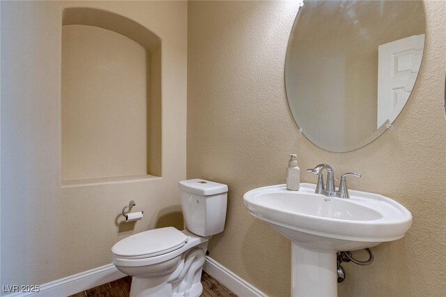 6403 Brandon Hills Ct, Las Vegas, NV 89139 - bathroom featuring wood finished floors, toilet, baseboards, and a sink