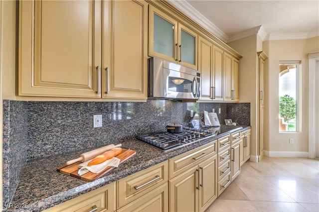 5162 Estasi St, Las Vegas, NV 89135 - kitchen with stainless steel appliances, cream cabinets, backsplash, baseboards, and light tile patterned floors