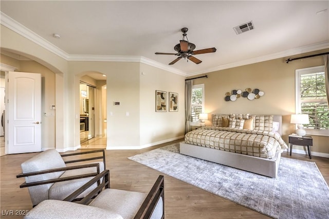 5162 Estasi St, Las Vegas, NV 89135 - bedroom featuring arched walkways, baseboards, crown molding, wood finished floors, and ceiling fan
