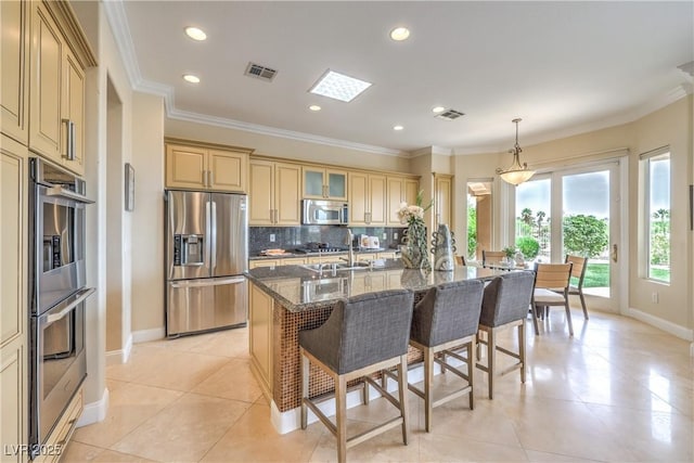5162 Estasi St, Las Vegas, NV 89135 - kitchen with stainless steel appliances, baseboards, a breakfast bar, dark stone countertops, and an island with sink