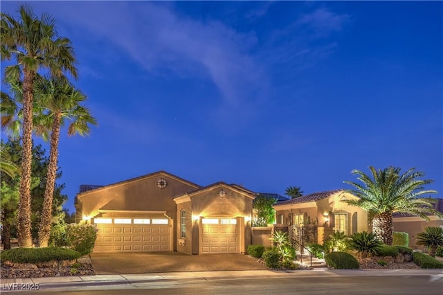 5162 Estasi St, Las Vegas, NV 89135 - mediterranean / spanish home featuring an attached garage, driveway, and stucco siding