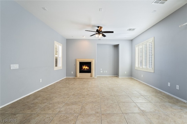 2482 Denholme St, Henderson, NV 89044 - unfurnished living room featuring ceiling fan, light tile patterned floors, a warm lit fireplace, and baseboards