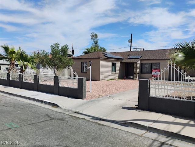4525 Fulton Pl, Las Vegas, NV 89107 - ranch-style house with roof mounted solar panels, a fenced front yard, a shingled roof, and a gate