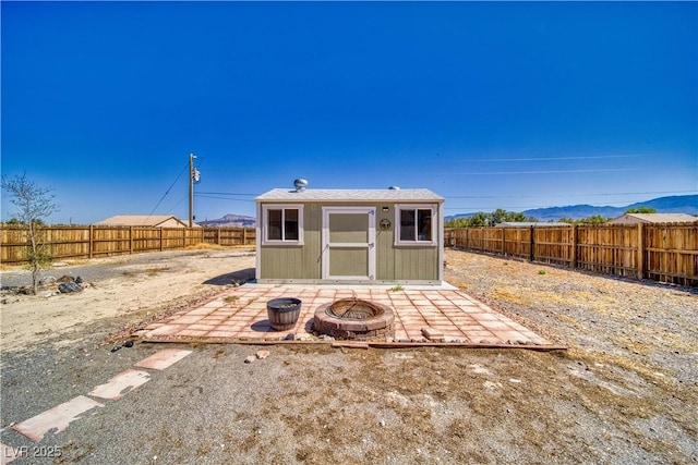 1190 W Sierra Vista Cir, Pahrump, NV 89060 - view of shed with an outdoor fire pit, a fenced backyard, and a mountain view