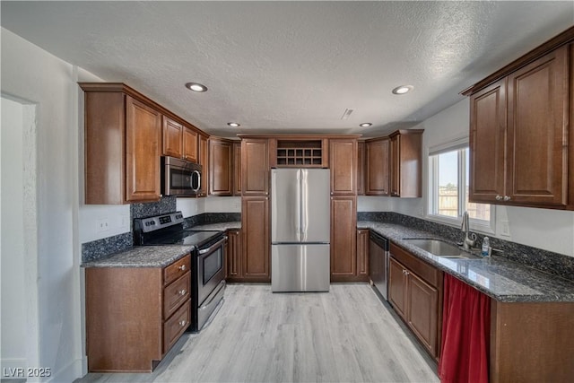 1190 W Sierra Vista Cir, Pahrump, NV 89060 - kitchen with stainless steel appliances, a sink, light wood-style flooring, recessed lighting, and dark stone countertops