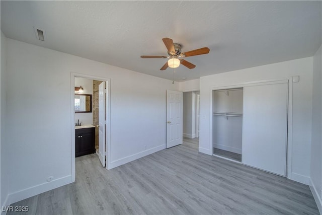 1190 W Sierra Vista Cir, Pahrump, NV 89060 - unfurnished bedroom featuring light wood-style floors, baseboards, a closet, a sink, and connected bathroom