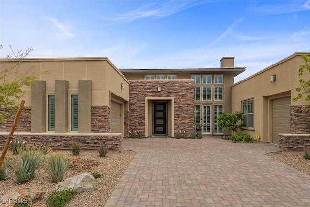 6700 Regency Stone Way, Las Vegas, NV 89148 - view of front of house featuring stone siding, stucco siding, decorative driveway, and an attached garage