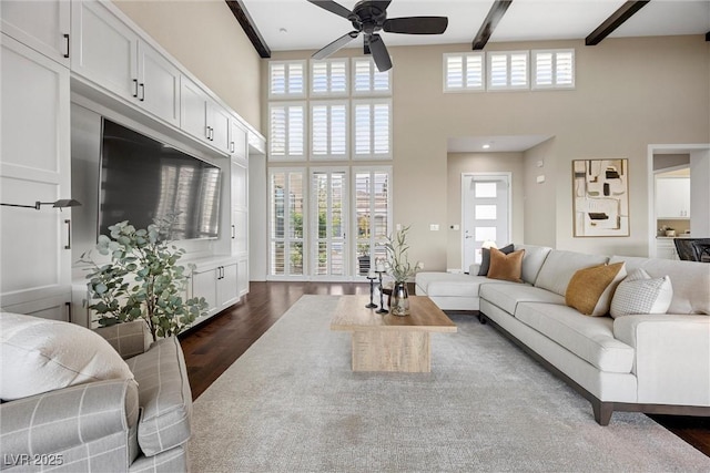 6700 Regency Stone Way, Las Vegas, NV 89148 - living room with a ceiling fan, a high ceiling, dark wood-style floors, healthy amount of natural light, and beamed ceiling