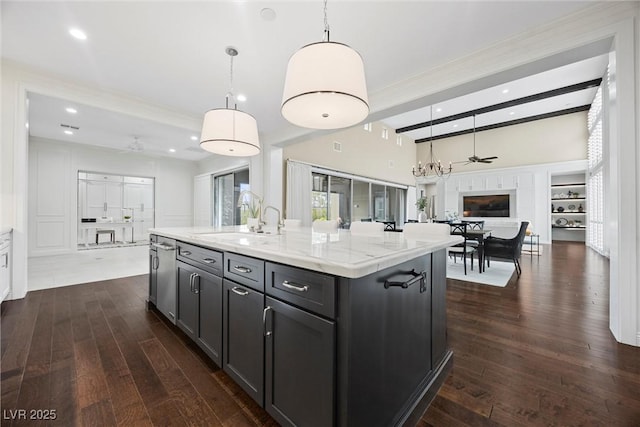 6700 Regency Stone Way, Las Vegas, NV 89148 - kitchen with open floor plan, dark wood finished floors, a sink, ornamental molding, and hanging light fixtures