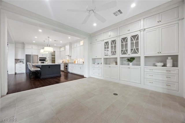 6700 Regency Stone Way, Las Vegas, NV 89148 - kitchen with white cabinetry, ceiling fan, light countertops, recessed lighting, and a breakfast bar area