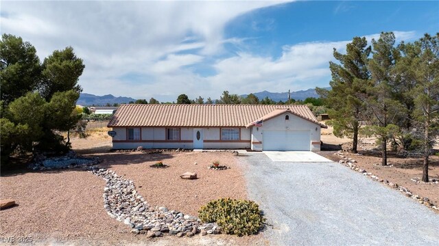 480 China St, Pahrump, NV 89048 - single story home with a mountain view, gravel driveway, stucco siding, an attached garage, and a tile roof