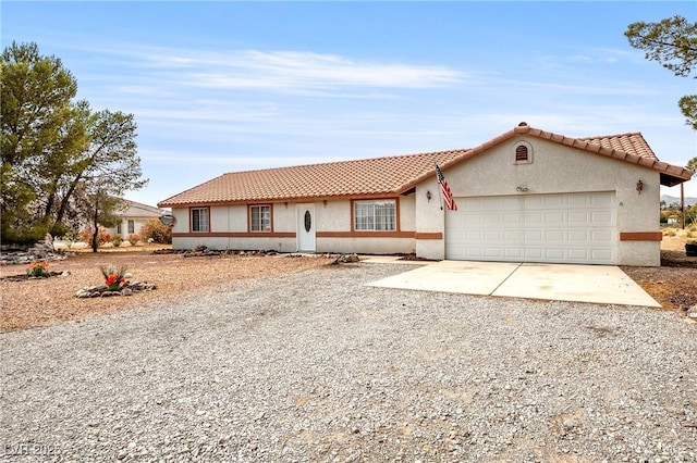 480 China St, Pahrump, NV 89048 - view of front of house featuring gravel driveway, an attached garage, stucco siding, and a tiled roof