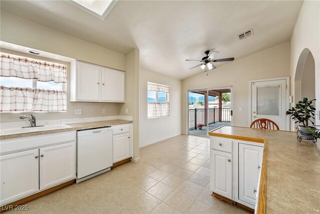 480 China St, Pahrump, NV 89048 - kitchen featuring dishwasher, a sink, vaulted ceiling, light countertops, and white cabinets
