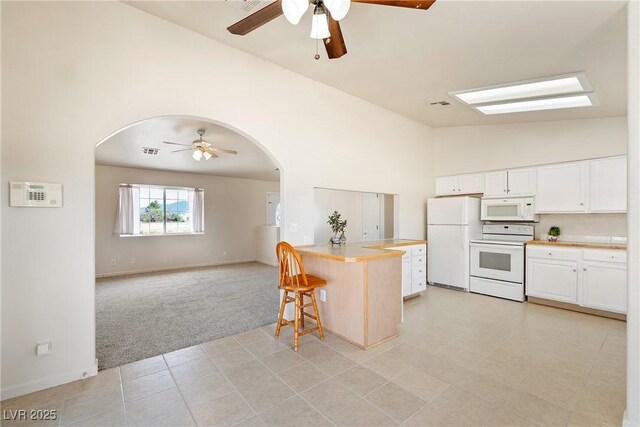 480 China St, Pahrump, NV 89048 - kitchen featuring white appliances, arched walkways, a ceiling fan, light carpet, and high vaulted ceiling