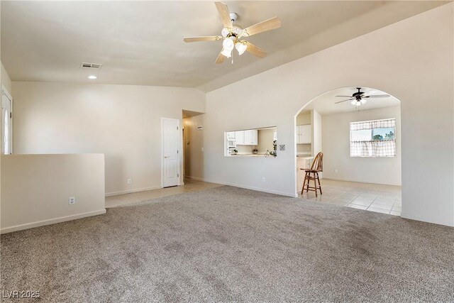 480 China St, Pahrump, NV 89048 - living room featuring ceiling fan, arched walkways, light colored carpet, vaulted ceiling, and baseboards