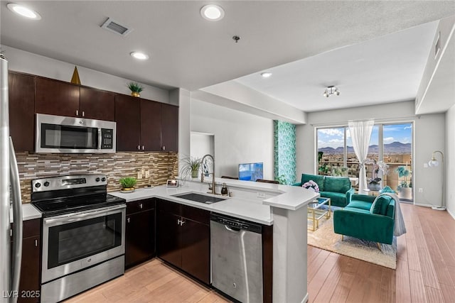 8255 Las Vegas Blvd Unit 1219, Las Vegas, NV 89123 - kitchen with stainless steel appliances, a sink, open floor plan, a peninsula, and light countertops