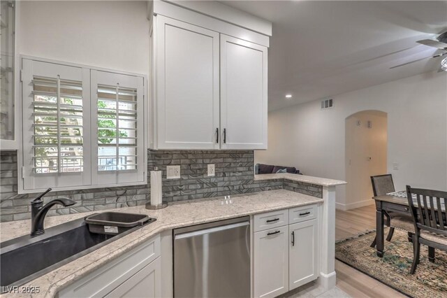 75 N Valle Verde Dr Unit 211, Henderson, NV 89074 - kitchen featuring dishwasher, a sink, arched walkways, a ceiling fan, and tasteful backsplash